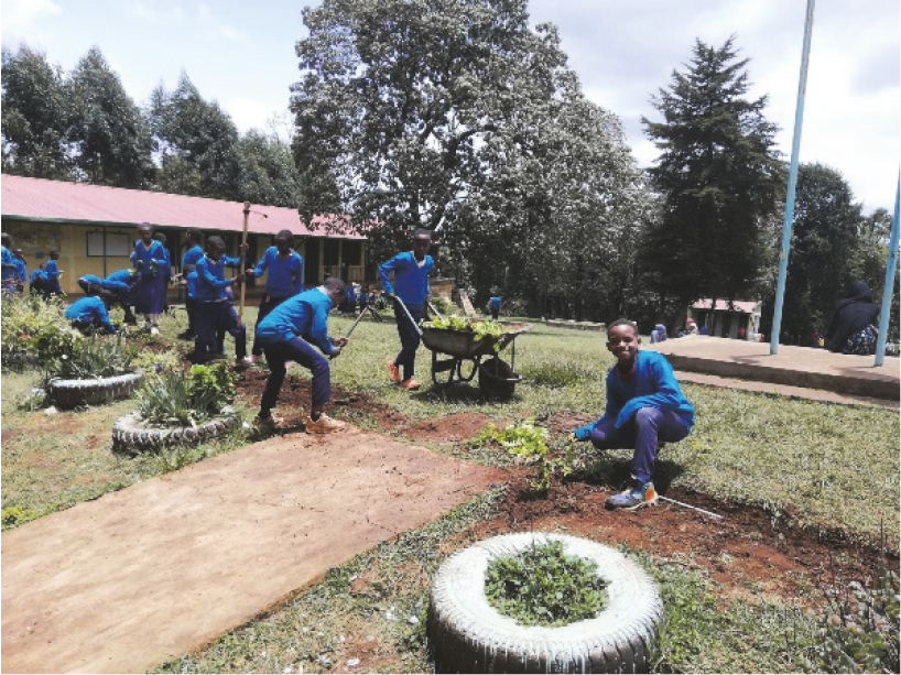 Schülerinnen und Schüler beim Blumen setzen / Sr. Gertrud Höggerl